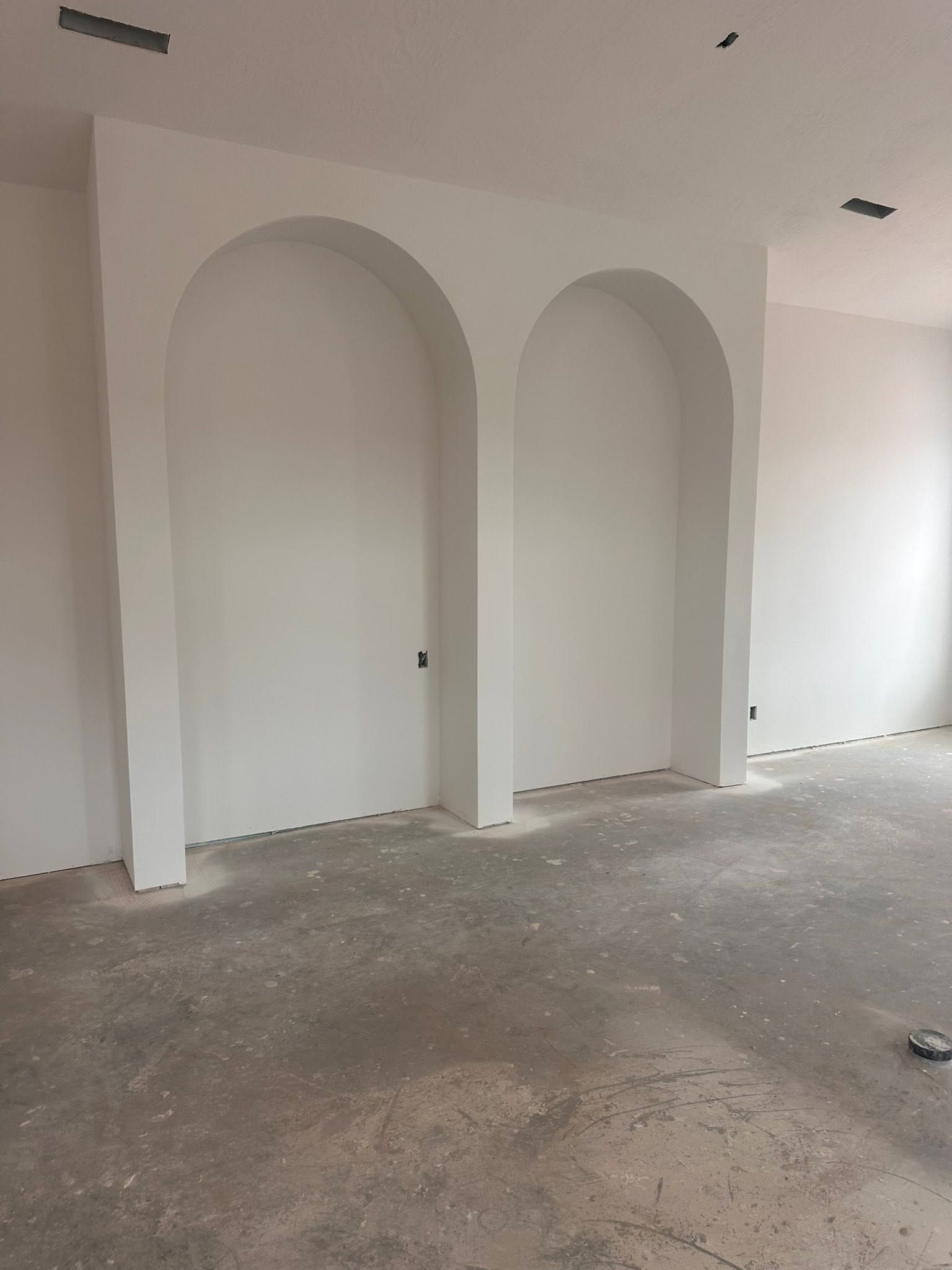 Two tall arched wall niches formed in foam and finished flush with the wall
