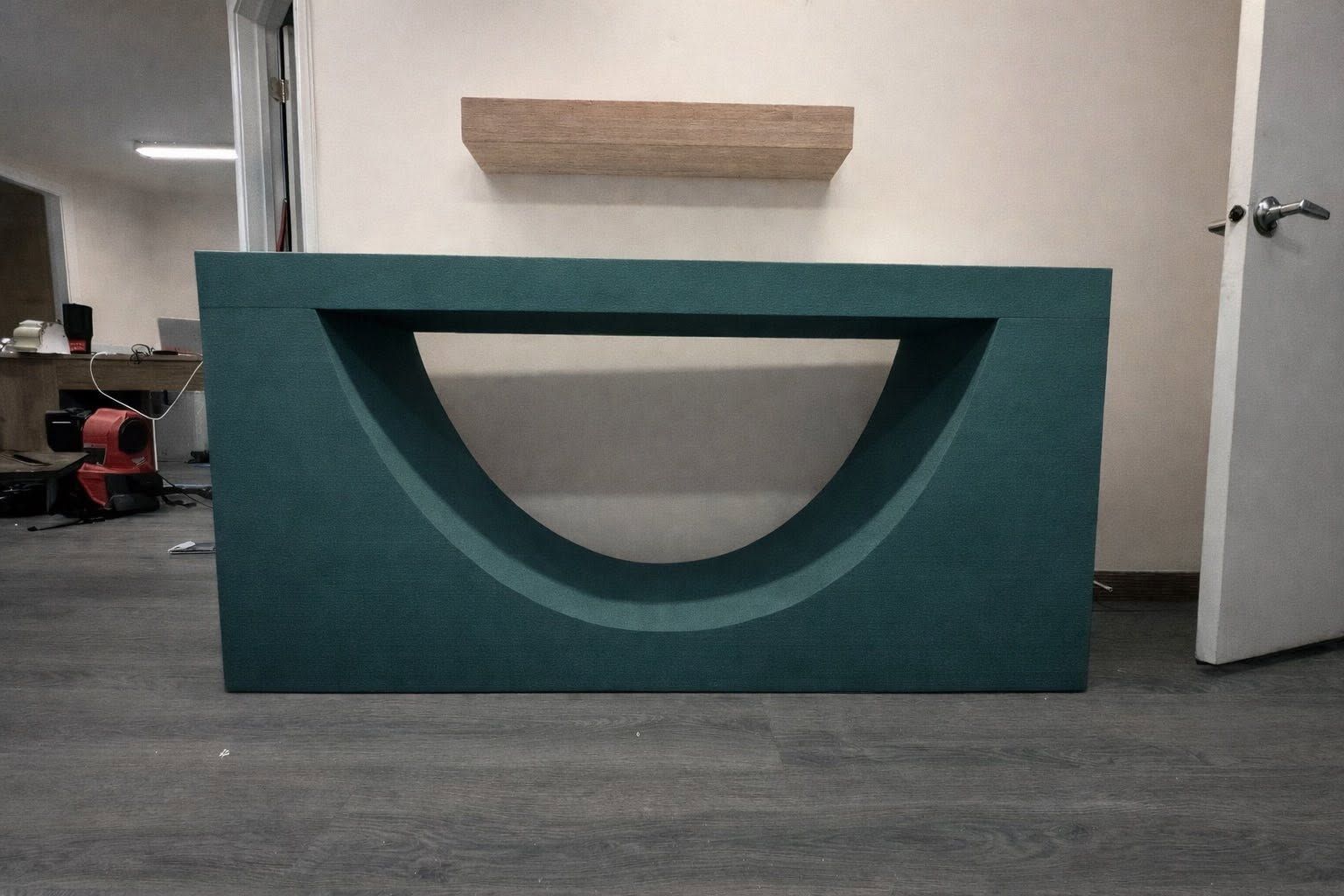 A teal foam console table with a deep arc cutout, finished in the shop