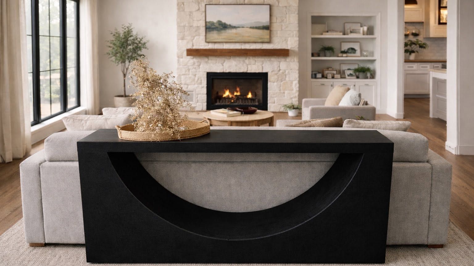 A black foam console table with a deep arc cutout behind a sofa in a living room