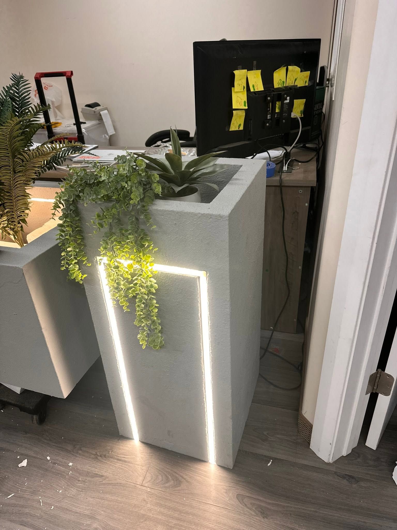 Tapered foam planters with recessed LED light channels being finished in the shop
